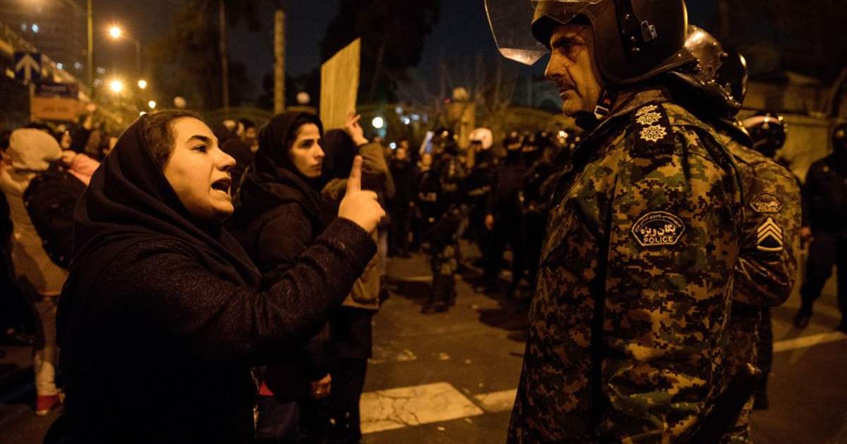 이란 수도 테헤란에 있는 아미르카비르 대학 앞에서 11일(현지시간) 혁명수비대의 우크라이나항공 여객기 격추에 항의하는 집회가 열린 가운데 한 여성이 경찰에 항의하고 있다. 테헤란 AP 연합뉴스