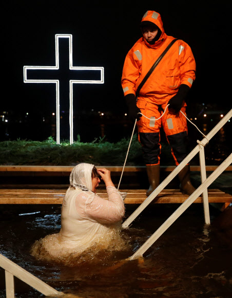 정교회 신도들이 19일(현지시간) 러시아 상트페테르부르크에서 공현 대축일을 맞아 차가운 물 속으로 뛰어들고 있다. 로이터 연합뉴스