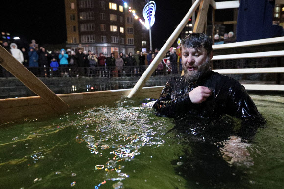 정교회 사제가 18일(현지시간) 러시아 모스크바에서 공현 대축일을 맞아 얼음물 속에서 성호를 긋고 있다. 타스 연합뉴스