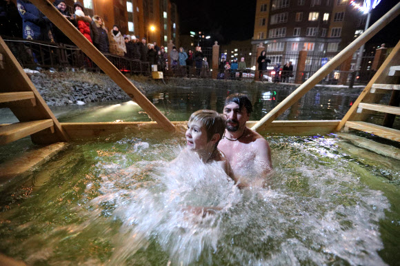 정교회 신도들이 18일(현지시간) 러시아 모스크바에서 공현 대축일을 맞아 얼음물 속으로 뛰어들고 있다. 타스 연합뉴스