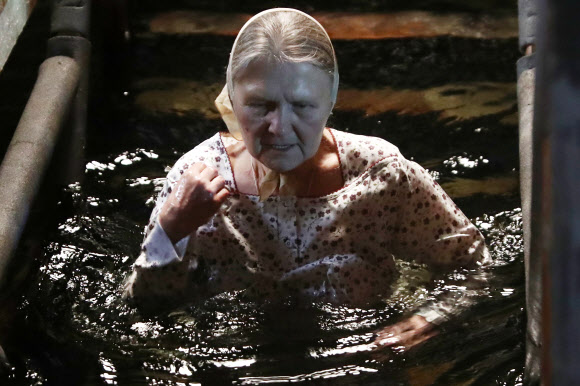 18일(현지시간) 정교회 신도가 러시아 모스크바에서 공현 대축일 전날 얼음물 속으로 뛰어들고 있다. 타스 연합뉴스