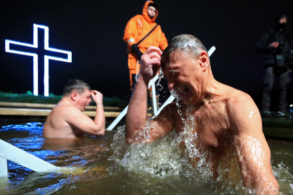 18일(현지시간) 정교회 신도가 러시아 콜피노에서 공현 대축일 전날 얼음물 속에서 성호를 긋고 있다. 타스 연합뉴스