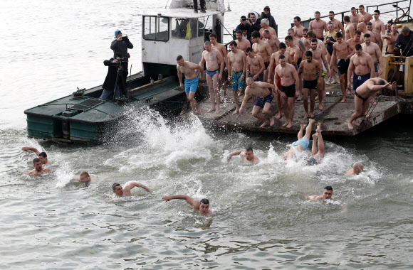 18일(현지시간) 세르비아 베오그라드에 있는 사바 강에 정교회 신도들이 뛰어들고 있다. AP 연합뉴스