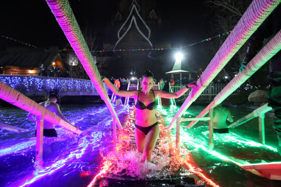 19일(현지시간) 러시아 모스크바 이즈마일로브 크렘린의 성 니콜라스 교회 근처에서 정교회 신자들이 공현 대축일을 맞아 얼음물에 들어 가고 있다. 타스 연합뉴스