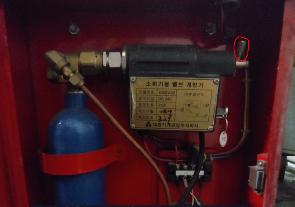 화재 시 이산화탄소를 배출해 불을 끄는 소화기용 밸브 개방기에 안전핀(빨간 원)이 꽂혀 있다. 안전핀이 있으면 버튼을 눌러도 작동하지 않는다. 