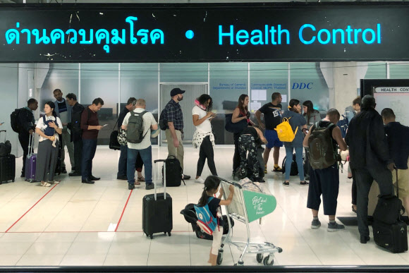 ‘우한 폐렴’ 검역 기다리는 방콕 공항 여행자들  태국을 찾은 여행자들이 19일 방콕의 항공 관문인 수완나품 국제공항의 입국장에서 줄을 지어 검역을 기다리고 있다. 태국은 중국 관광객이 많이 찾는 국가 중 하나이며 수완나품을 비롯한 여러 공항에서 우한 직항편이 운항되고 있다. 2020. 1.20 방콕 로이터 연합뉴스