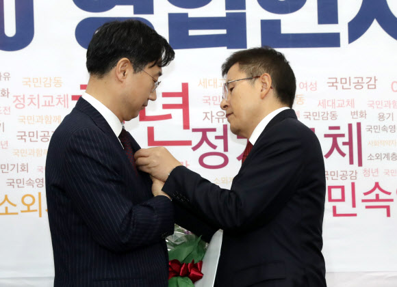 자유한국당 황교안 대표가 21일 오전 서울 여의도 국회에서 열린 영입인사 환영식에서 다섯번째 영입인사인 외교·안보 전문가인 신범철 아산정책연구원 안보통일센터장(왼쪽)에게 한미동맹 강화의 의미가 담긴 배지를 선물하고 있다.  신 센터장은 1995년부터 한국국방연구원에서 북한 문제와 함께 외교·안보 분야 등에서 연구 활동을 펼쳐온 전문가다. 2020.1.21  연합뉴스