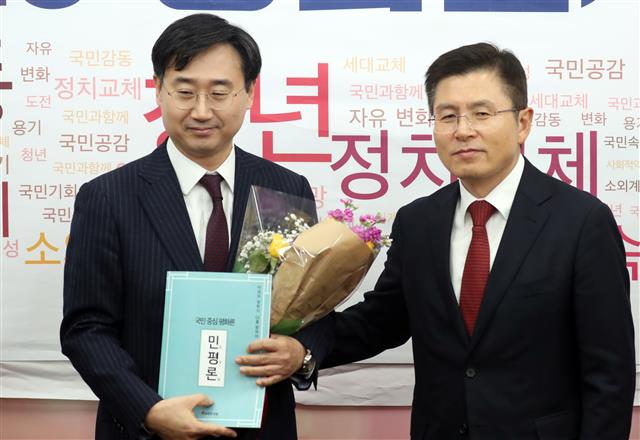 자유한국당 2020 영입인사 5호인 신범철 전 아산정책연구원 안보통일센터장이 21일 서울 여의도 국회에서 열린 환영식에서 황교안 대표로 부터 꽃다발과 민평론 책자를 받고 있다. 2020.1.21 뉴스1