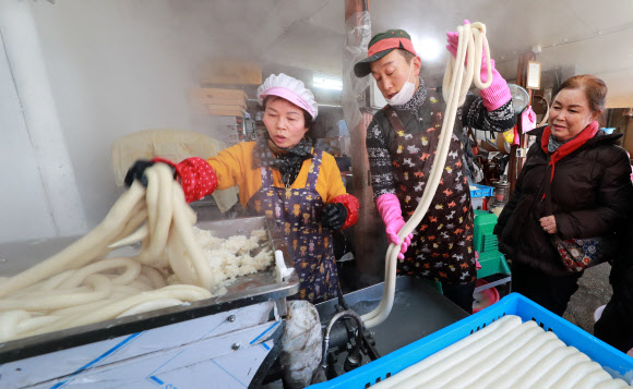 설 연휴를 나흘 앞둔 21일 오전 경남 함양군 함양읍 남양 떡집에서 상인들이 분주하게 가래떡을 뽑고 있다. 2020.1.21  함양군 제공