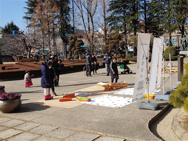 설 연휴 부산박물관을 찾은 시민들이 박물관 앞마당에서 윷놀이를 하고 있다.