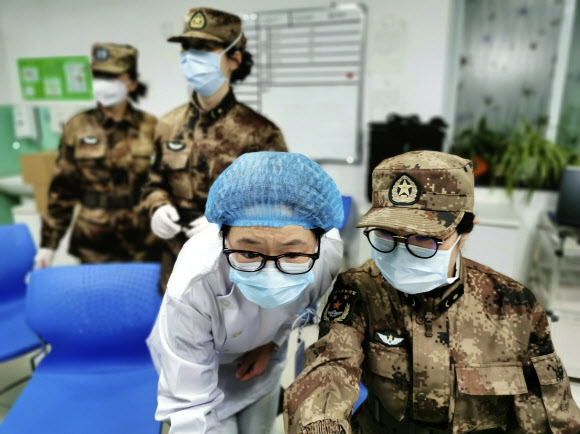 중국 인민해방군 소속 의료지원단원이 지난 26일 신종 코로나바이러스 진원지인 허베이성 우한시의 진인탄 병원 의료진에게서 업무를 넘겨받고 있다.  우한 신화 연합뉴스