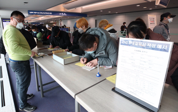 28일 오전 인천국제공항 1터미널 입국장에서 중국 톈진에서 입국한 사람들이 검역소에서 건강상태질문서를 작성하고 있다. 질병관리본부는 신종 코로나 바이러스와 관련해 중국 전역을 검역대상 오염지역으로 지정하고 전체 입국자를 대상으로 검역과 건강상태질문서 제출을 의무화 했다. 2020. 1.28 박윤슬 기자 seul@seoul.co.kr