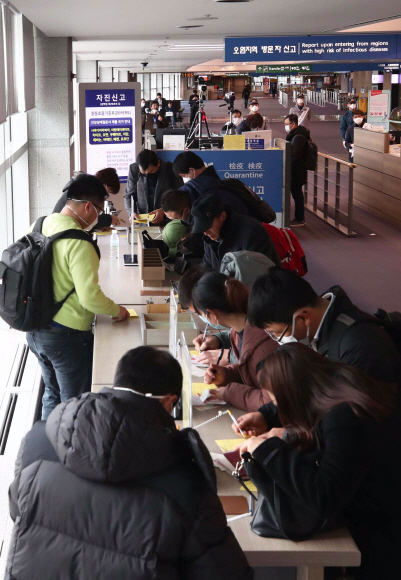 28일 오전 인천국제공항 1터미널 입국장에서 중국 톈진에서 입국한 사람들이 검역소에서 건강상태질문서를 작성하고 있다. 질병관리본부는 신종 코로나 바이러스와 관련해 중국 전역을 검역대상 오염지역으로 지정하고 전체 입국자를 대상으로 검역과 건강상태질문서 제출을 의무화 했다. 2020. 1.28 박윤슬 기자 seul@seoul.co.kr