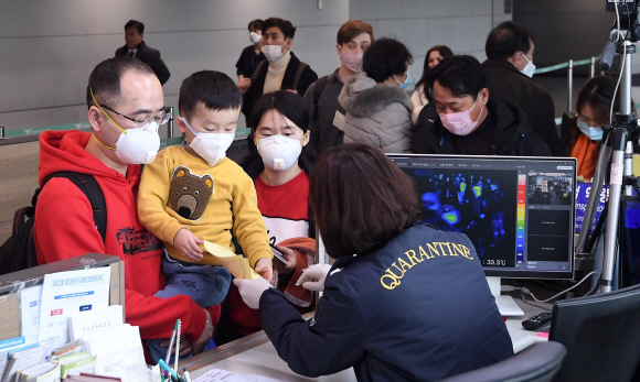 신종 코로나바이러스 감염증 네 번째 확진자가 발생하며 확산 우려가 고조되고 있는 28일 인천국제공항 입국장에서 검역 관계자들이 중국 지난에서 입국한 관광객들을 대상으로 검역을 하고 있다. 보건당국은 이날부터 신종 코로나바이러스 감염증 확산을 막고자 중국에서 들어오는 모든 입국자의 ‘건강상태질문서’ 제출을 의무화했다. 2020. 1.28 박윤슬 기자 seul@seoul.co.kr