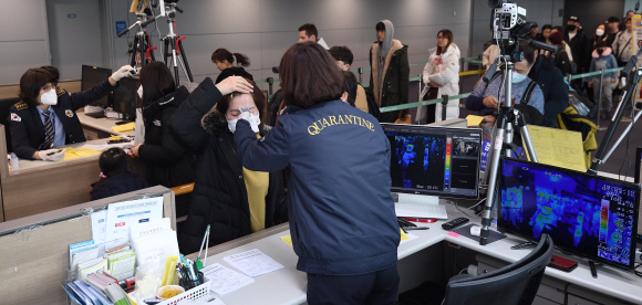신종 코로나바이러스 감염증 네 번째 확진자가 발생하며 확산 우려가 고조되고 있는 28일 인천국제공항 입국장에서 검역 관계자들이 중국 텐진에서 들어온 입국자을 대상으로 검역을 하고 있다. 보건당국은 이날부터 신종 코로나바이러스 감염증 확산을 막고자 중국에서 들어오는 모든 입국자의 ‘건강상태질문서’ 제출을 의무화했다. 2020. 1.28 박윤슬 기자 seul@seoul.co.kr