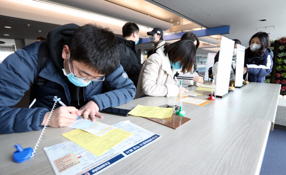 28일 오전 인천국제공항 1터미널 입국장에서 중국 상하이에서 입국한 사람들이 검역소에서 건강상태질문서를 작성하고 있다. 질병관리본부는 신종 코로나 바이러스와 관련해 중국 전역을 검역대상 오염지역으로 지정하고 전체 입국자를 대상으로 검역과 건강상태질문서 제출을 의무화 했다. 2020. 1.28 박윤슬 기자 seul@seoul.co.kr