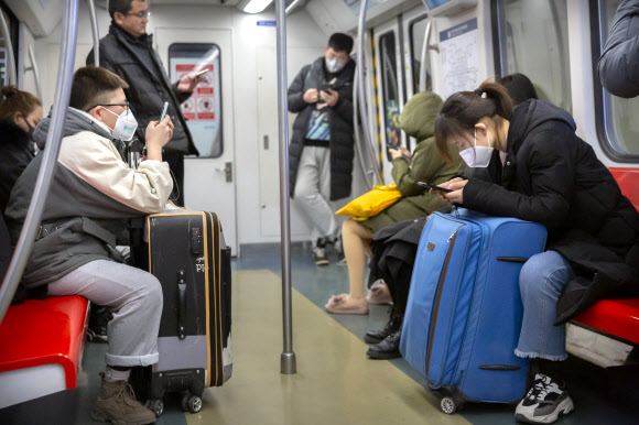신종 코로나바이러스가 중국 전역으로 확산하는 가운데 수도 베이징의 지하철에서 시민들이 마스크를 쓰고 있다. 2020.1.27  AP 연합뉴스