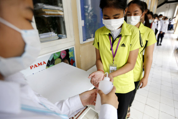 신종코로나 확진자 1명이 발생한 캄보디아의 한 고등학교에서 28일 학생들이 수업을 듣기 전에 손을 소독하고 있다. 연합뉴스  