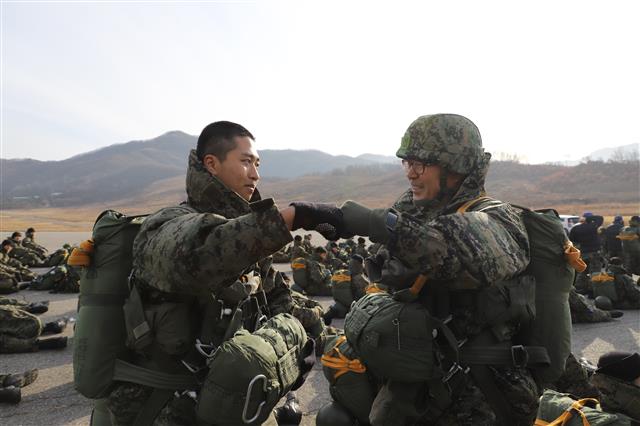 다음달 전역을 앞두고 고별 강하에 나선 김정우(오른쪽) 원사가 29일 첫 강하훈련에 참가한 특전부사관후보생을 격려하고 있다. 육군 제공