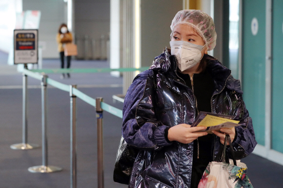 신종 코로나바이러스 감염증에 대한 우려가 커지는 가운데 29일 중국 진안과 톈진에서 인천국제공항으로 입국하는 여행객이 각양각색으로 대비한 채 들어서고 있다. 사진은 헤어캡과 방진 마스크를 쓴 여성. 박윤슬 기자 seul@seoul.co.kr