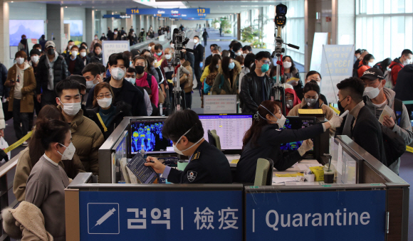29일 중국 광저우에서 출발한 항공기를 타고 국내로 입국한 여행객들이 인천국제공항 제1터미널 입국장에서 검역 질의서를 제출하며 발열 검사를 받고 있다. 박윤슬 기자 seul@seoul.co.kr