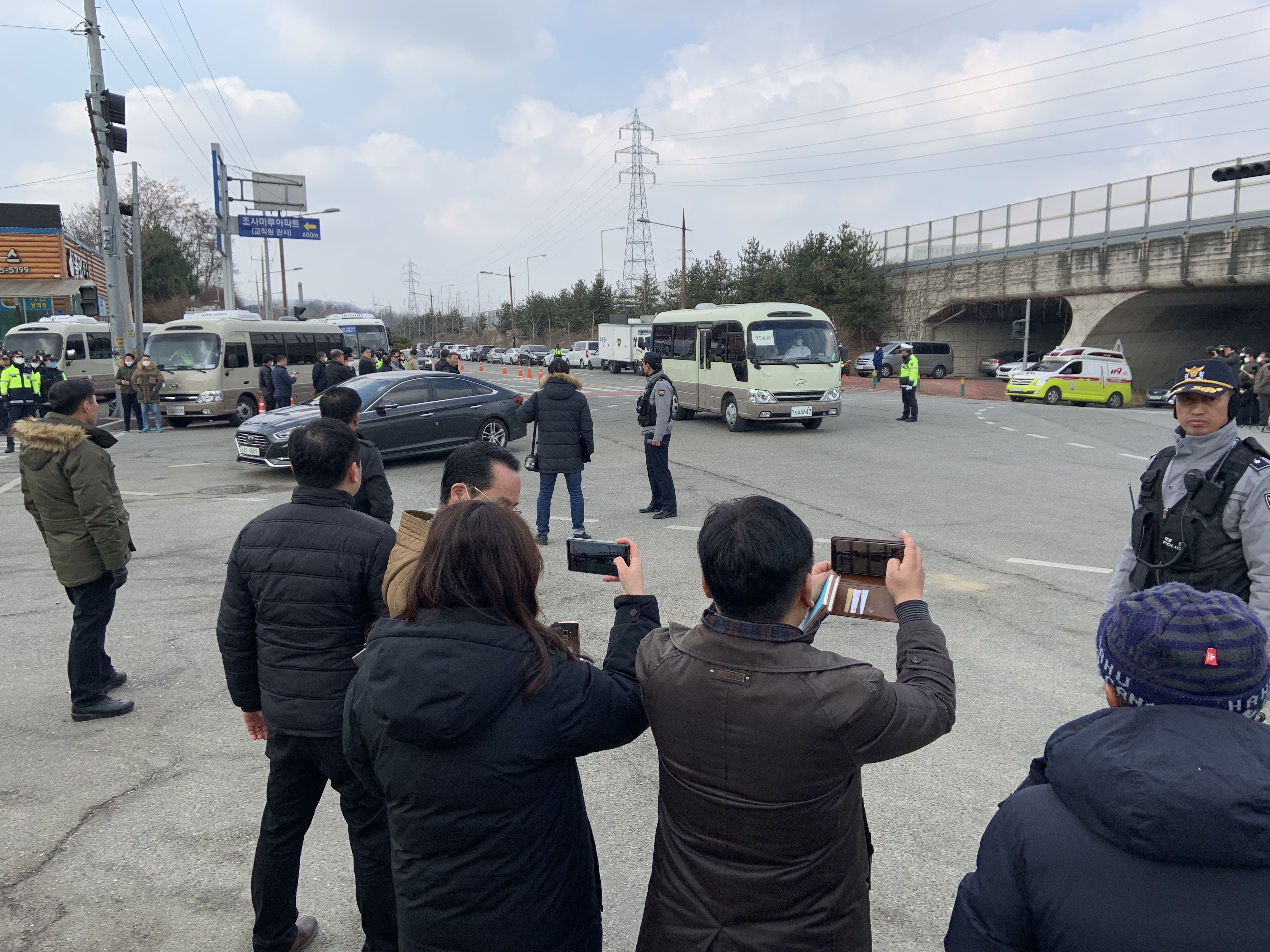 31일 낮 충남 아산 경찰인재개발원에 우한 교민 탑승 버스들이 들어오는 모습을 주민과 취재진이 지켜보고 있다. 이천열 기자