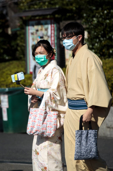 일본 도쿄를 방문한 관광객들이 3일 신종 코로나바이러스 전염을 막기 위해 마스크를 쓴 채 유명 사찰인 센소지에서 일본 전통의상 체험을 하고 있다. 일본에서는 이날 오전 9시 현재 20명의 확진자가 발생했다. 도쿄 AFP 연합뉴스