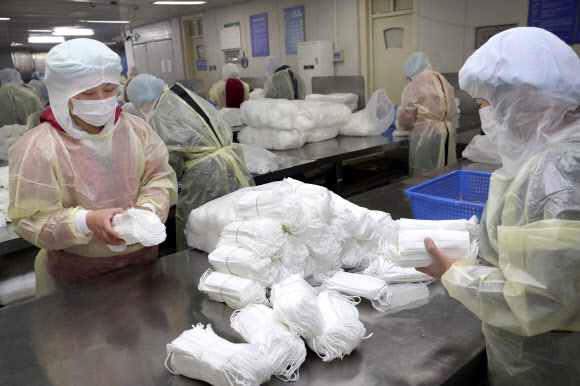 지난달 27일 중국의 한 마스크 공장에서 직원들이 생산된 마스크를 포장하고 있다. AP통신