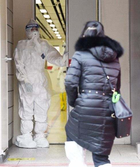 5일 국립중앙의료원에서 선별진료실을 찾은 한 여성이 마스크 등을 착용한 의료진과 검사를 받기 위해 이동하고 있다. 중앙의료원 측은 2번 확진 환자가 이날 격리 해제될 예정이라며 시간은 환자와 협의하고 있다고 밝혔다. 또 지난 4일 2번 환자에게 실시한 세번째 유전자 증폭 검사에서도 음성 판정이 났다고 말했다. 2020.2.5 오장환 기자 5zzang@seoul.co.kr