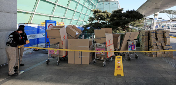 신종 코로나바이러스 감염증이 확산하는 가운데 인천국제공항 여객터미널에서 대량의 마스크를 택배 상자에 옮겨 담던 외국인이 경찰에 붙잡혔다. 5일 인천공항경찰단에 따르면 경찰은 마스크를 택배 상자에 옮긴(이른바 ‘박스갈이’) 한 홍콩인을 인천공항경찰단 사무실로 임의동행했고, 조만간 조사할 예정이다. 이 홍콩인이 국내에서 구입한 것으로 추정되는 마스크는 1만개가량인 것으로 전해졌다. 사진은 6일 오전 통제된 현장 모습. 2020.2.6  연합뉴스