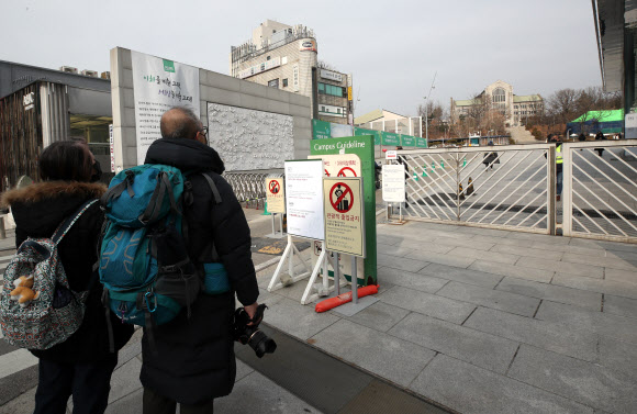 7일 오전 서울 서대문구 이화여대 정문 앞에 신종 코로나바러스 위험 수준 격상으로 인한 관광객의 학교 출입을 제한한다는 내용이 표시된 안내판이 설치돼 있다. 또 감염 위험 해제시까지 정문 차량 입ㆍ출입을 통제하고 있다.  2020.2.7  연합뉴스