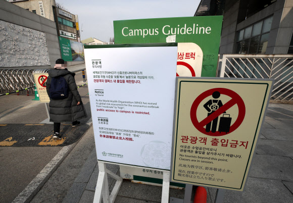 7일 오전 서울 서대문구 이화여대 정문 앞에 신종 코로나바러스 위험 수준 격상으로 인한 관광객의 학교 출입을 제한한다는 내용이 표시된 안내판이 설치돼 있다. 또 감염 위험 해제시까지 정문 차량 입ㆍ출입을 통제하고 있다.  2020.2.7  연합뉴스
