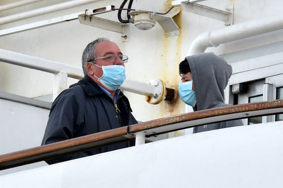 7일(현지시간) 일본 요코하마 다이코쿠 피어 크루즈 터미널에 정박해 있는 대형 크루즈선 ‘다이아몬드 프린세스’호의 승객들이 마스크를 쓰고 있다. AFP 연합뉴스