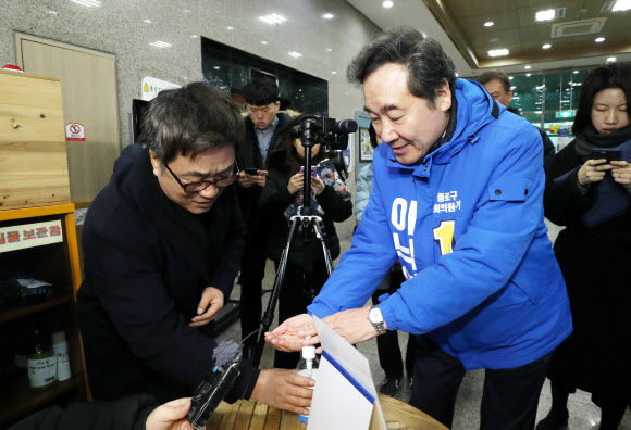 더불어민주당 후보로 종로 출마를 선언한 이낙연 전 국무총리가 10일 서울 종로구민회관을 찾아 지역주민과 인사를 나누기 전 손을 소독하고 있다. 2020.2.10  연합뉴스