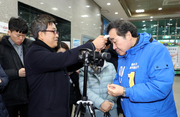 더불어민주당 후보로 종로 출마를 선언한 이낙연 전 국무총리가 10일 서울 종로구민회관을 찾아 지역주민과 인사를 나누기 전 체온을 측정하고 있다. 2020.2.10  연합뉴스