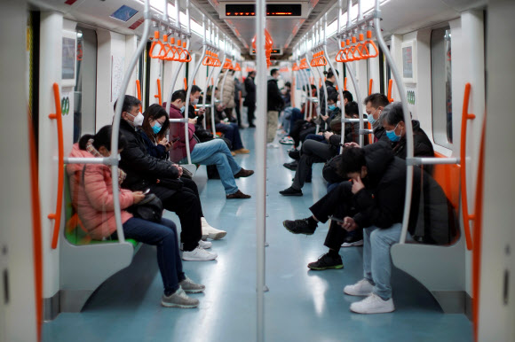 10일 오전 중국 상하이시에서 신종 코로나 바이러스 감염증 발병으로 공장 가동 중단이 늦춰진 가운데 푸동의 한 지하철에는 마스크를 착용한 사람들이 앉아있다. 상하이 로이터 연합뉴스
