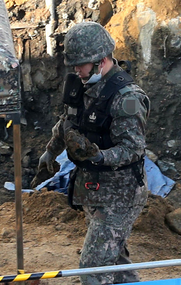 11일 오전 박격포탄 형태의 폭발물이 무더기로 발견된 서울 구로구의 한 신축공사 현장에서 군 관계자가 포탄으로 추정되는 물체를 옮기고 있다. 지난 10일 경찰은 폭발물로 추정되는 물체가 묻혀 있다는 공사장 작업자의 신고를 받고 현장에 출동, 수색을 통해 폭발물 총 88발을 발견했다고 밝혔다. 2020.2.11  연합뉴스