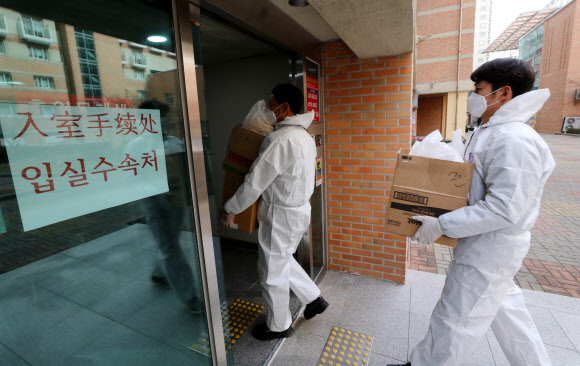 11일 오전 광주 북구 전남대학교 생활관(기숙사)에서 신종 코로나바이러스 감염증 확산을 방지하기 위해 기숙사 내에 격리 중인 중국 유학생들에게 도시락을 전달하기 위해 직원들이 방역복을 입고 내부로 들어가고 있다. 2020.2.11  연합뉴스