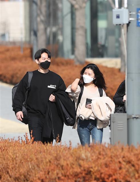 서울 한낮 기온이 13도 등 올해 들어 가장 포근한 봄 날씨를 보인 11일 서울 서대문구 연세대학교에서 학생들이 외투를 손에 들고 이동하고 있다. 2020.2.11 뉴스1
