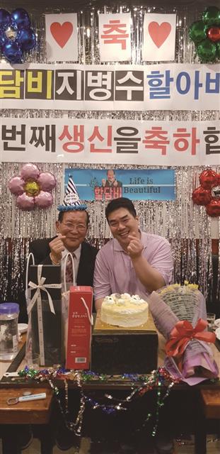 지난해 생일파티에 참석한 지인과 함께 손가락 하트를 보이면서 즐거워하고 있다. 애플북 제공