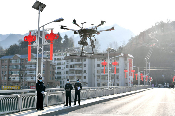 Police officers operate a drone to spread information about the prevention and control of the new coronavirus, in Baokang