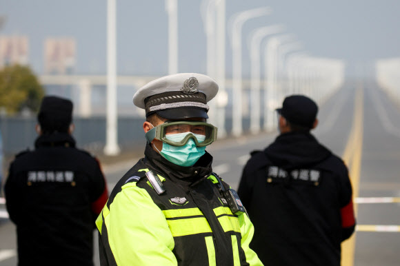 A police officer wears a face mask and goggles at a checkpoint at the Jiujiang Yangtze River Bridge