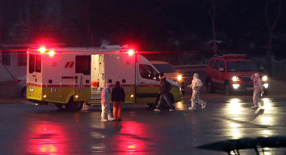 신종 코로나바이러스 감염증 발원지 중국 우한(武漢)에 남은 교민과 이들의 중국인 가족을 데려오기 위해 투입된 세 번째 전세기가 12일 새벽 김포국제공항에 도착해 한 교민이 응급차로 향하고 있다. 2020. 2.12 박윤슬 기자 seul@seoul.co.kr