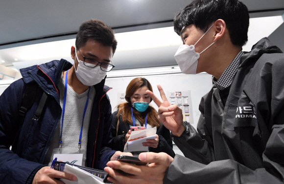 자가진단앱 설치하는 여행객들