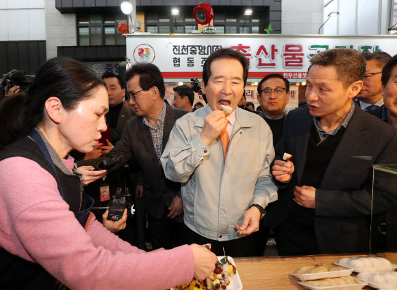 정세균 국무총리가 15일 오전 충북 진천 중앙시장을 방문해 떡을 맛보고 있다. 2020.2.15  연합뉴스