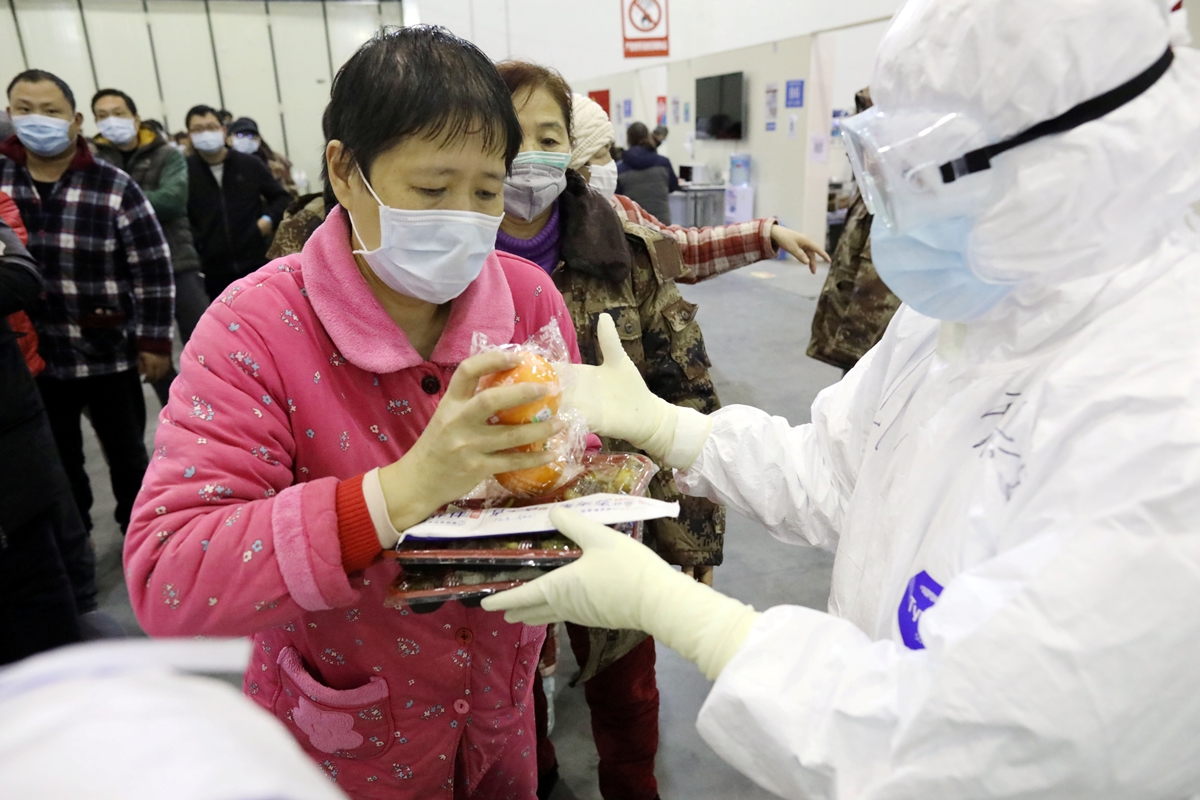 중국 후베이성 우한의 한 전시장에 설치된 코로나19 임시 병동에서 15일 환자들이 점심 식사를 받아가고 있다. 2020.2.15  로이터 연합뉴스