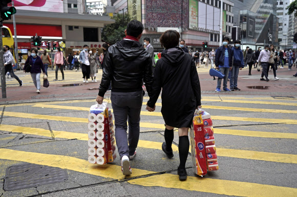 홍콩에서 코로나19가 확산하자 시민들이 생필품을 사재기 하는 가운데 한 커플이 14일 화장지를 몽땅 사 들고 가고 있다. 2020.2.14  AP 연합뉴스 
