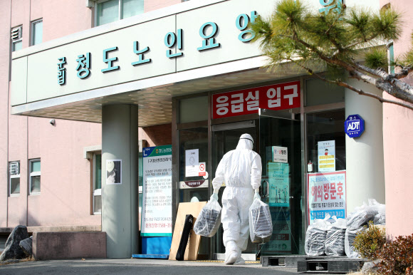 22일 오후 경북 청도대남병원에서 방호복을 입은 의료진들이 도시락을 옮기고 있다. 2020.2.22 연합뉴스