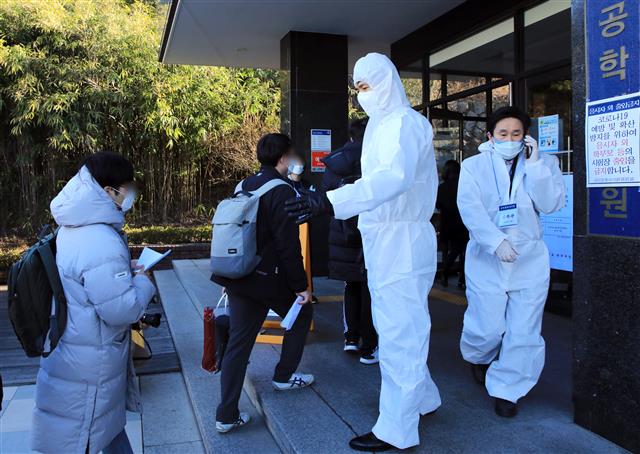 23일 서울 성동구 한양대에 마련된 공인회계사(CPA) 1차시험장에서 신종코로나바이러스감염증(코로나19) 확산 우려에 방진복과 마스크를 쓴 관계자가 응시생들을 안내하고 있다. 서울, 부산, 대구, 광주, 대전 등 5곳의 7개 대학에서 치러지는 이번 CPA 1차 시험은 1만874명이 지원했다. 2020.2.23 뉴스1