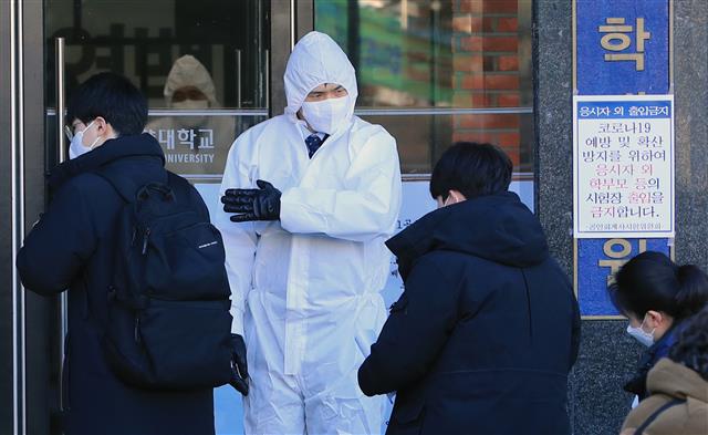 23일 서울 성동구 한양대에 마련된 공인회계사(CPA) 1차시험장에서 신종코로나바이러스감염증(코로나19) 확산 우려에 방진복과 마스크를 쓴 관계자가 응시생들을 안내하고 있다. 서울, 부산, 대구, 광주, 대전 등 5곳의 7개 대학에서 치러지는 이번 CPA 1차 시험은 1만874명이 지원했다. 2020.2.23 뉴스1